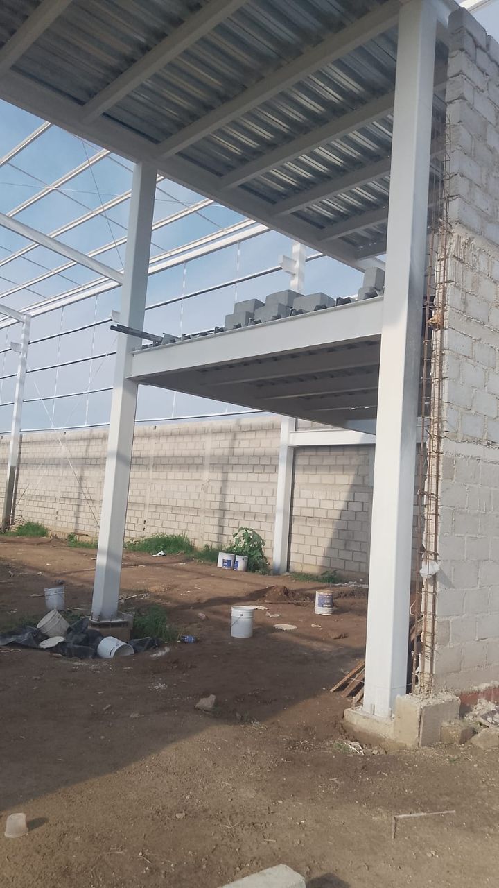 Detalle de la conexión soldada entre columna y trabe de acero en una nave industrial