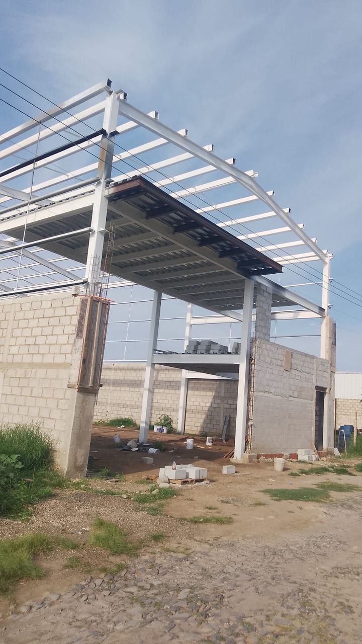 Estructura de acero de una nave industrial con marcos rígidos y cubierta de lámina en proceso de montaje