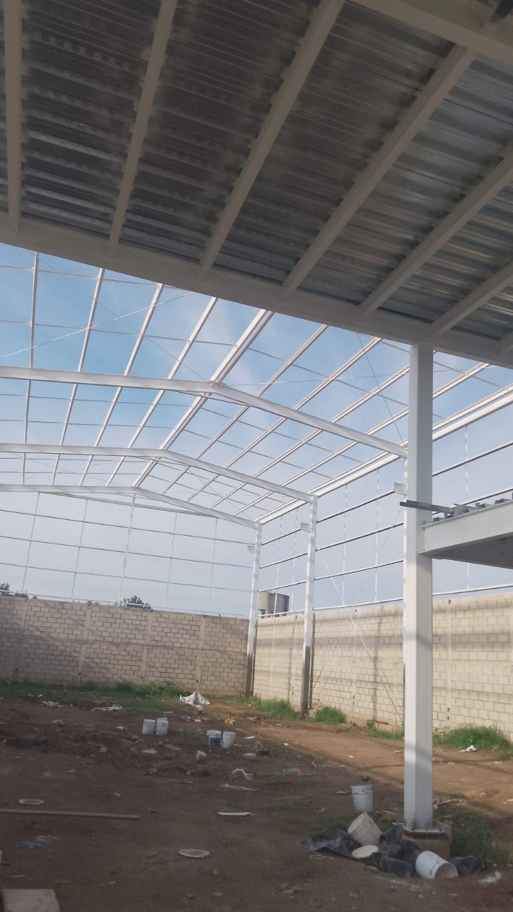 Vista interior de la cubierta de una bodega: armaduras de acero, tensores y lámina galvanizada