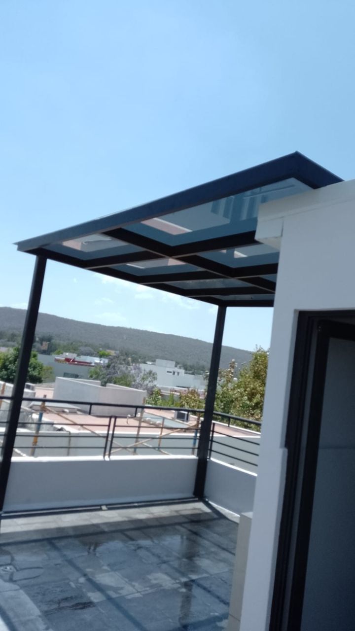 Pérgola con cubierta de policarbonato sobre estructura metálica, con vista panorámica al valle